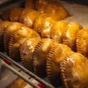 Homemade golden hand pies arranged on a bakery display shelf, inviting and fresh.